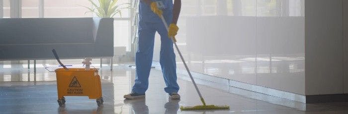 Hospital employee mopping with bucket