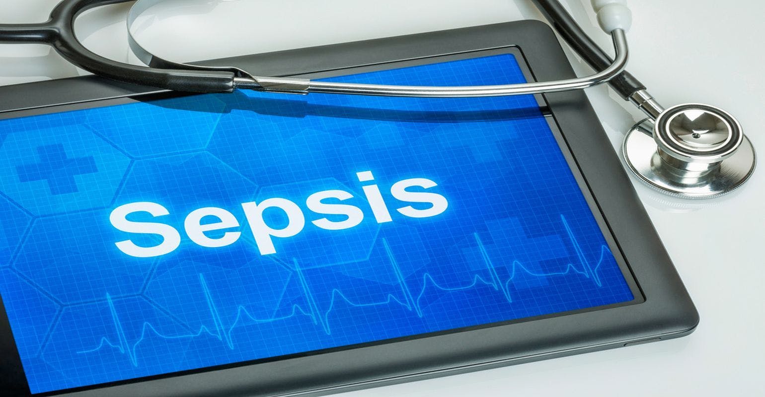 a tablet with the word "sepsis" on it sitting beside a stethoscope. 