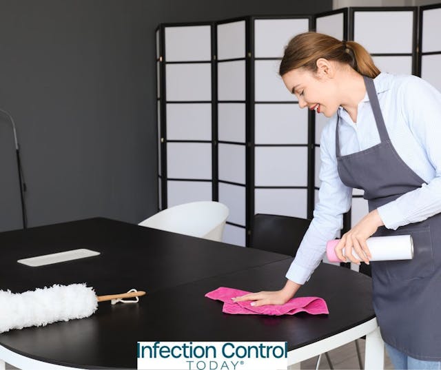 Female environmental hygienist cleaning a table in an office  (Adobe Stock 659254451 by Pixel-Shot)