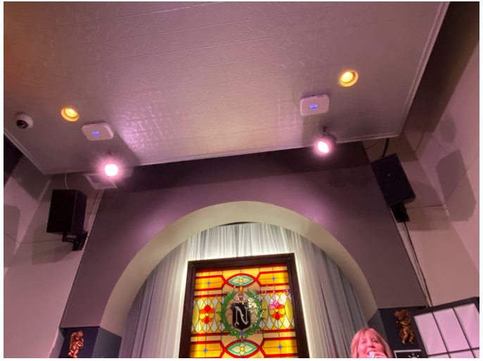 Figure 4. The installation of 222-nm far UV fixtures in a Boston piano bar where singing occurs. The fixtures are the 2 square devices that resemble smoke detectors. A cone of 222-nm GUV produces high equivalent ACH air disinfection in the breathing zone. (Photo courtesy of the author)