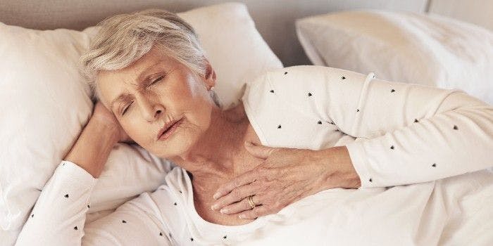 older woman with lying in bed with the flu