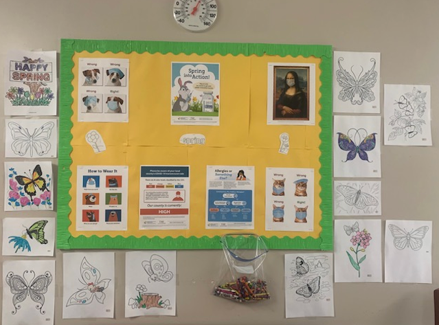 IPC Bulletin board with crayons and pictures of butterflies and flowers.  (Photo courtesy of author)