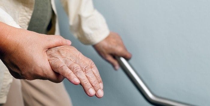 Health care worker holding elderly patient hand and patient holding handrail 