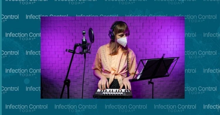 A female DJ plays a synthesizer with a mask on.     (Adobe Stock 475319246 by BULAT YAHUDZIN)