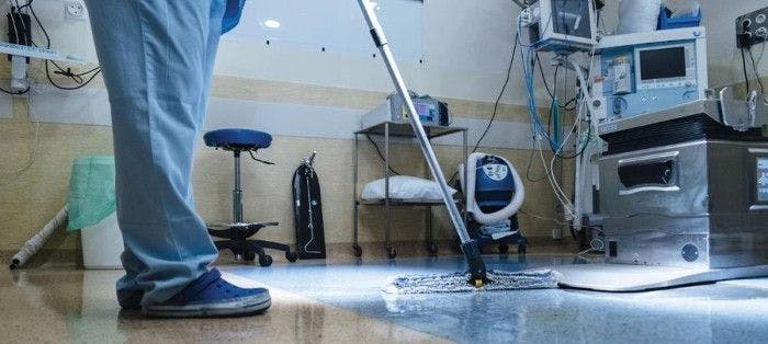 an environmental services worker mopping a hospital floor
