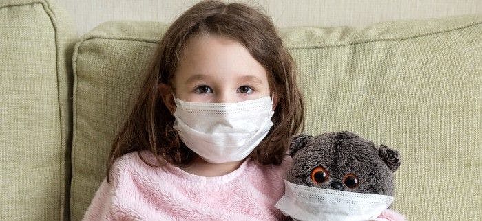 Little girl and her teddy bear wearing masks