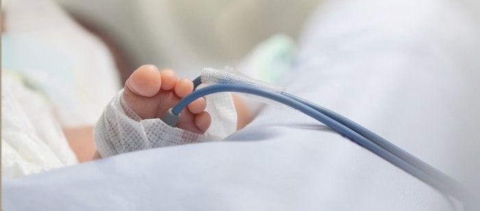 a baby's tiny foot wrapped with gauze while in a NICU. 